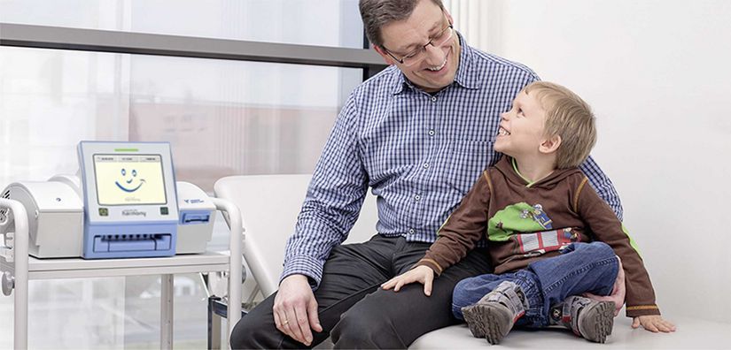 Father sitting with son on hospital bed